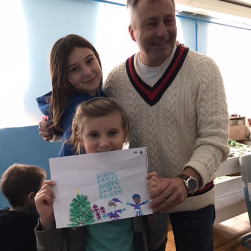 young girl holds a thank you drawing